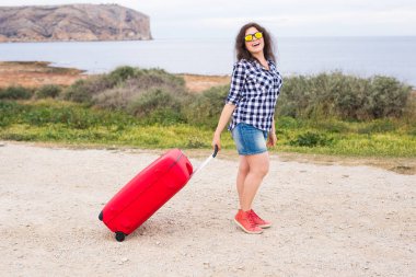 İnsanlar, tatil ve seyahat kavramı - deniz çanta arka plan üzerinde duran güzel genç kadın