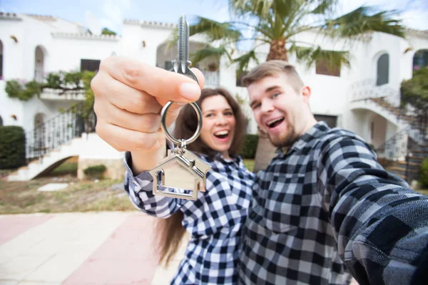 New Home, imobiliário e conceito em movimento - Engraçado jovem casal mostra chaves de casa nova . — Fotografia de Stock