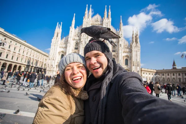 Seyahat ve tatil kavramı - Milano Duomo Katedrali önünde komik güvercinler ile kendi kendine portre alarak mutlu turistler kış — Stok fotoğraf