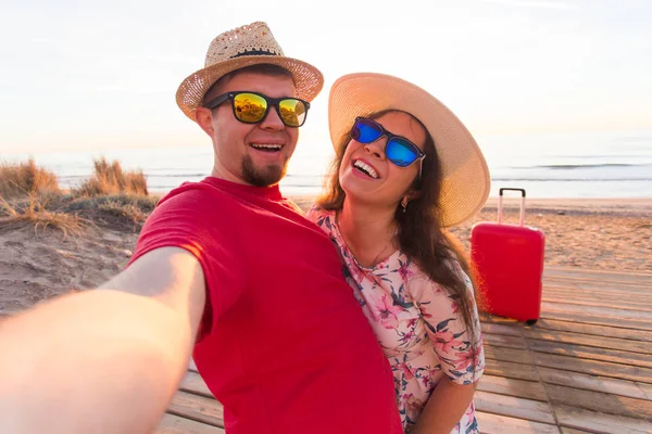 Conceito de viagem e férias - Jovem casal feliz apaixonado leva retrato selfie na praia — Fotografia de Stock