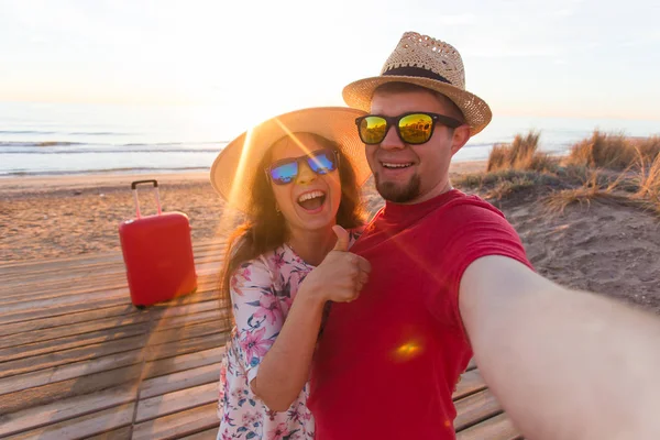 Conceito de viagem e férias - Jovem casal feliz apaixonado leva retrato selfie na praia — Fotografia de Stock