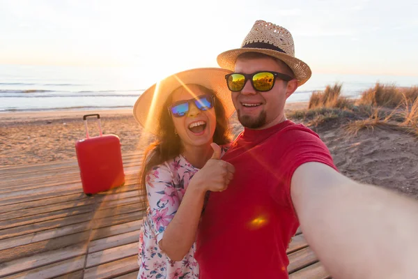 Reise- und Urlaubskonzept - glückliches junges verliebtes Paar macht Selfie-Porträt am Strand — Stockfoto