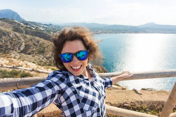 Vakantie-, vakantie- en reisinformatie concept - Happy jonge vrouw selfie overname prachtige landschap — Stockfoto