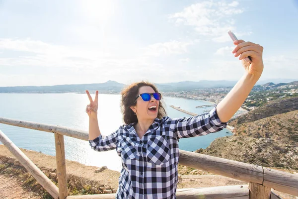 Seyahat, tatil ve tatil kavramı - selfie güzel peyzaj üzerinde alarak mutlu genç kadın — Stok fotoğraf