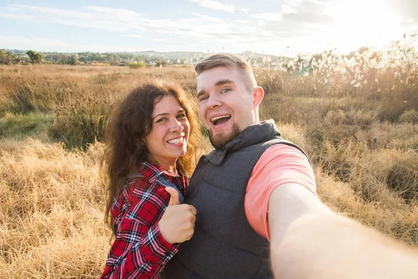 Cestování, dovolená, léto a dovolená koncept - šťastný pár pořizování selfie venku — Stock fotografie