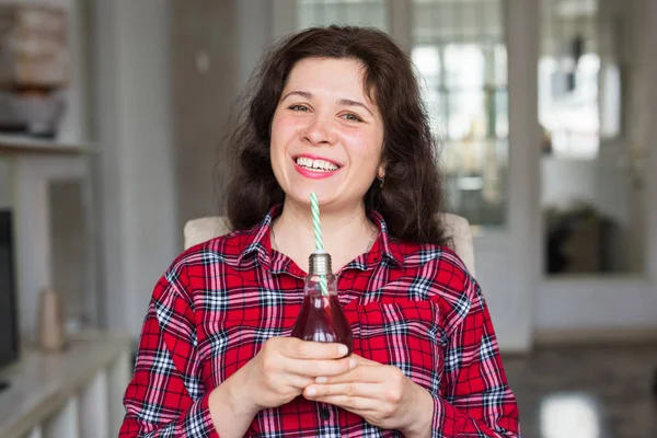 Dieet, gezonde levensstijl en detox concept - jonge vrouw met kersensap in fles ziet eruit als een lamp — Stockfoto