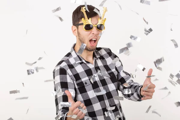 People, holidays and party concept - funny guy in glasses dancing in confetti on white background — Stock Photo, Image