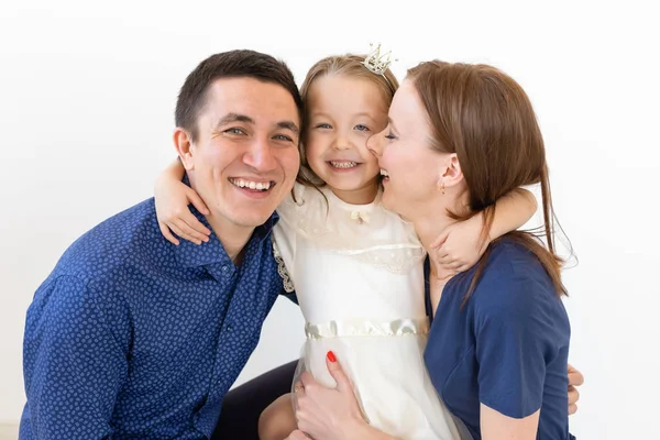 Concepto de familia, padres e hijos - Familia encantadora con una pequeña hija linda sobre fondo blanco — Foto de Stock