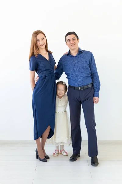 Concepto de personas, familia y felicidad - Madre y padre con hija pequeña sobre fondo blanco —  Fotos de Stock