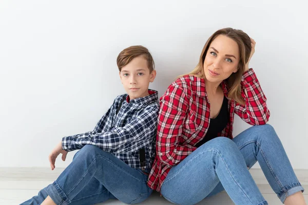 Moeders dag, kinderen en familie concept - schattige tiener jongen met zijn jonge moeder thuis — Stockfoto