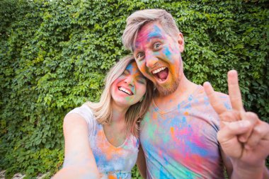 Festival holi ve teknoloji kavramı - genç çift selfie festivalde yapma