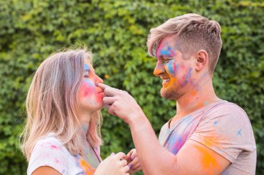 Festival holi, arkadaş, insanlar kavramı - birlikte festival oynayan genç Çift