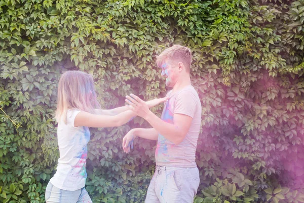 Amistad, festival de holi, concepto de personas - pareja joven jugando con colores en el festival de holi — Foto de Stock