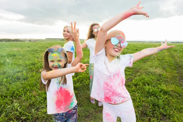 Festival de Holi, concepto de amistad y vacaciones - jóvenes mujeres en el baile de color y divertirse —  Fotos de Stock