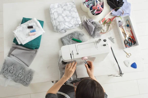 Tailor, fashion and seamstress concept - young female fashion designer in her showroom, top view — Stock Photo, Image