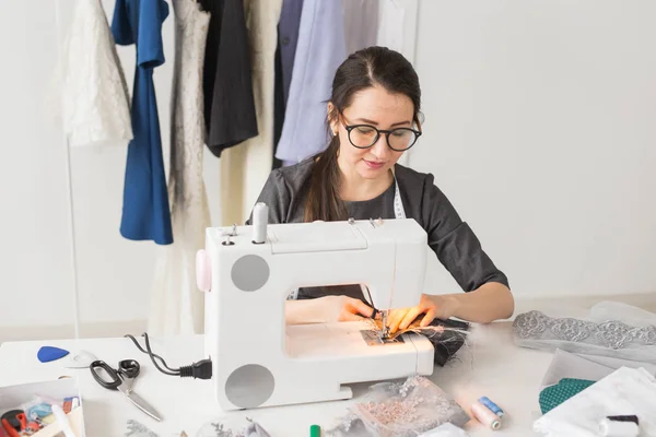Gens, concept de mode et showroom - jeune créateur de mode coud des vêtements sur une machine à coudre — Photo