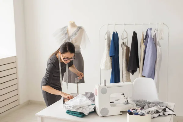 Dressmaker, tailor, fashion and showroom concept - Portrait of talented female dressmaker working with textile for sewing clothes