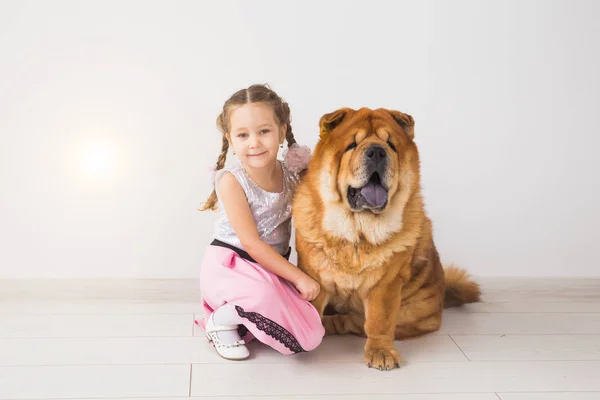 Pet, crianças e conceito de família - Menina e sua mãe abraçando cão chow-chow sobre fundo branco — Fotografia de Stock