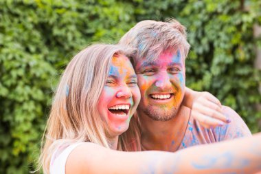 Festival holi ve teknoloji kavramı - genç çift selfie festivalde yapma