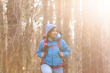 Macera, seyahat, turizm, zam ve insanlar kavramı - sırt çantaları ile sonbahar doğal arka plan üzerinde yürüyen turist kadın gülümseyerek