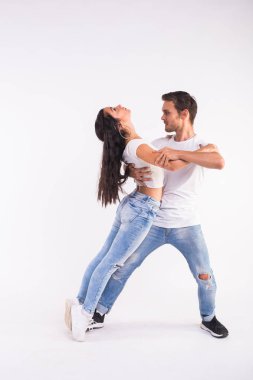 Genç çift sosyal latin dans dans bachata, merengue, salsa. Beyaz arka plan üzerinde iki zerafet poz