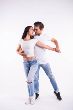 Genç çift sosyal latin dans dans bachata, merengue, salsa. Beyaz arka plan üzerinde iki zerafet poz