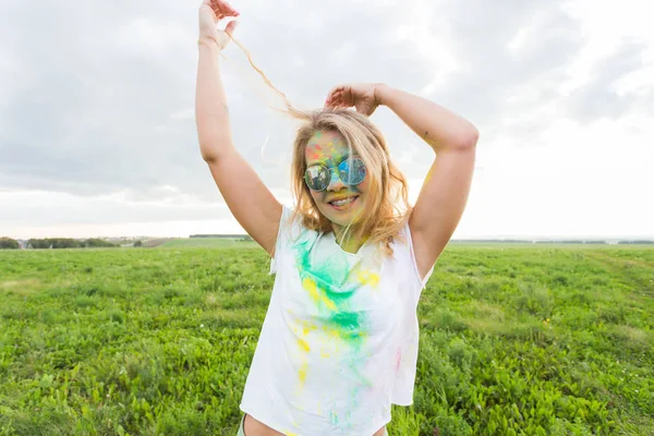 Diversión, feliz, gente y el concepto de vacaciones - Joven mujer alegre en la fiesta de pintura Holi —  Fotos de Stock