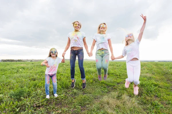 Festival Holi, vacances et concept de bonheur - les jeunes adolescents et les femmes en couleurs s'amusent en plein air — Photo