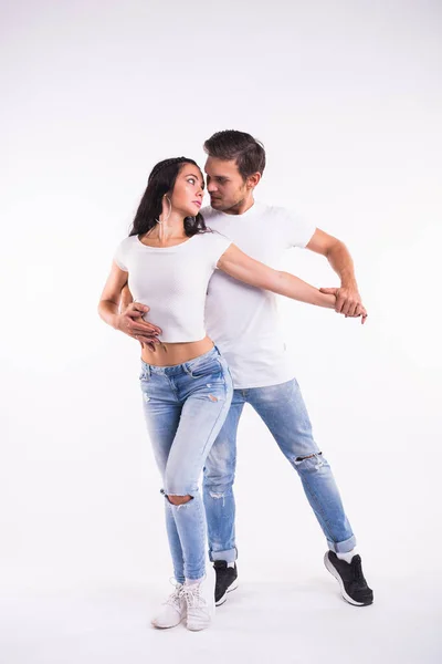 Jeune couple dansant danse sociale latine bachata, merengue, salsa. Deux pose d'élégance sur fond blanc — Photo