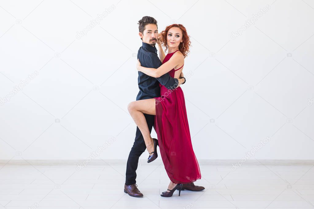 Social dance, bachata, kizomba, salsa, tango concept - Close up portrait of woman man dressed in beautiful outfits over white background with copy space