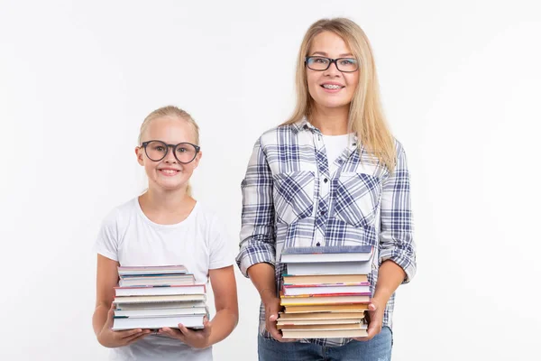 Wissen, Lesen und Bildungskonzept - Mutter und Tochter mit Büchern auf weißem Hintergrund. — Stockfoto