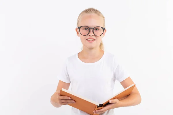 Bildung, Menschen, Kinder und Schulkonzept - Schüler mit Brille halten Buch in der Hand auf weißem Hintergrund — Stockfoto