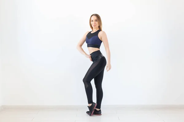 Gente, fitness y deporte concepto de pie joven mujer deportiva sobre fondo blanco —  Fotos de Stock