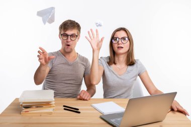 Oynak, yaramaz öğrenciler kağıt uçak ve masada oturan buruşuk kağıt atma büyük gözlüklü