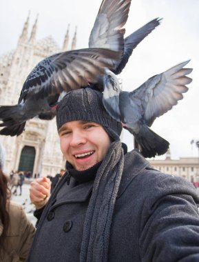 Kış seyahat ve tatil kavramı - mutlu turist Milano Duomo Katedrali önünde komik güvercinler ile kendi kendine portre çekici