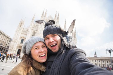 Milano Duomo Meydanı'nda güvercin ile kendi kendine portre çekici çift. Kış seyahat, İtalya ve ilişki kavramı