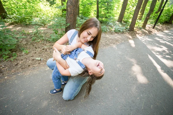 Naturaleza, maternidad y concepto de niño - Madre feliz e hija pequeña se divierten en el parque verde — Foto de Stock