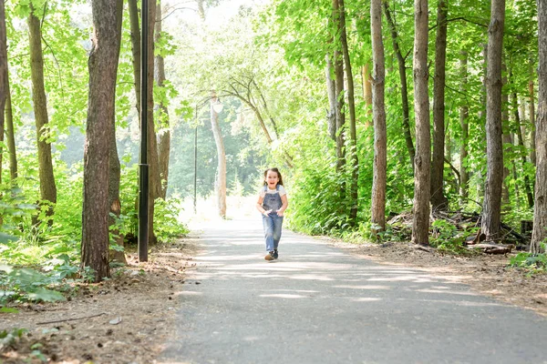 Kinderen, jeugd en natuur concept - portret van mooi klein kind meisje loopt door het park — Stockfoto