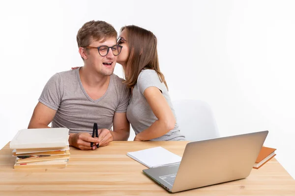 Människor och utbildning koncept - par studenter viskar — Stockfoto