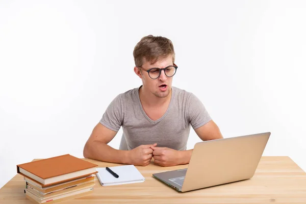 El estudio, la educación y el concepto de emociones - estudiante masculino haciendo ejercicios en el ordenador portátil. Está perplejo. — Foto de Stock