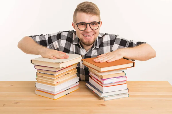 Persone, conoscenza e concetto di istruzione - Felice divertente studente vestito con camicia a quadri seduto al tavolo di legno con libri — Foto Stock