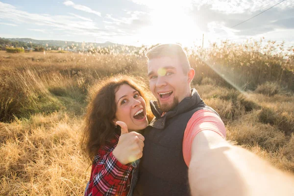 Reise, Urlaub und Naturkonzept - glückliches Paar beim Selfie auf einem Feld — Stockfoto
