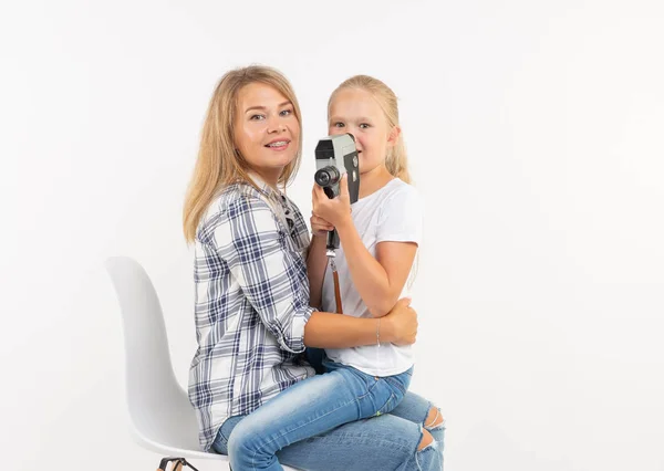 Család, a fotózás és a hobbi koncepció - nő és gyermeke használ egy régi vágású fényképezőgép fehér háttér — Stock Fotó