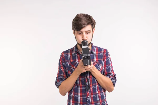 Concepto vintage y de personas: el hombre mira a través de la cámara retro sobre el fondo blanco —  Fotos de Stock