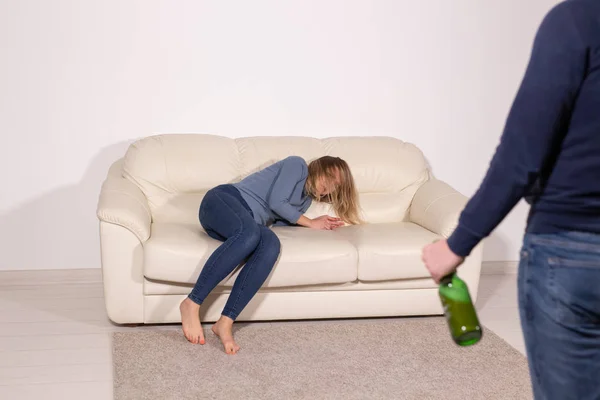 人, 暴力和虐待概念----妻子喝酒而妻子躺在沙发上的男子 — 图库照片