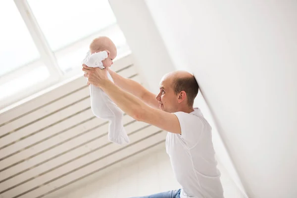 Barn, familj och faderskap koncept - glad skallig far håller baby dotter i vita rummet bakgrund — Stockfoto