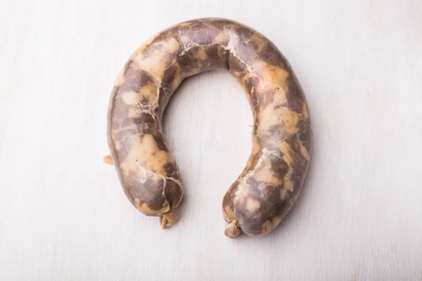 Food, meat and delicious concept - sausage made with horse meat on the table — Stock Photo, Image