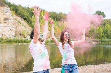 Festival holi, tatil, turizm ve doğa kavramı - kadın ve erkek portre çok renkli toz kaplı.