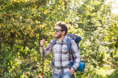 Uzun yürüyüşler, turizm ve doğa kavramı - sırt çantası konumu orman arka plan üzerinde olan genç yolcusu