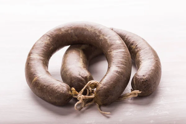 Food, meat and delicious concept - sliced horse meat sausage with cumin — Stock Photo, Image